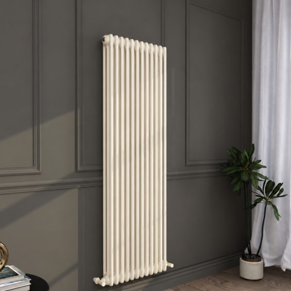 Tall white vertical radiator mounted on a dark panelled wall next to a window with white curtains, a potted plant, and a small table with books and decor.