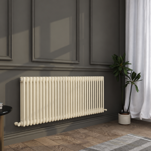 A cream-coloured radiator mounted on a dark grey panelled wall beside a potted plant, with sunlight coming through a window with white curtains.